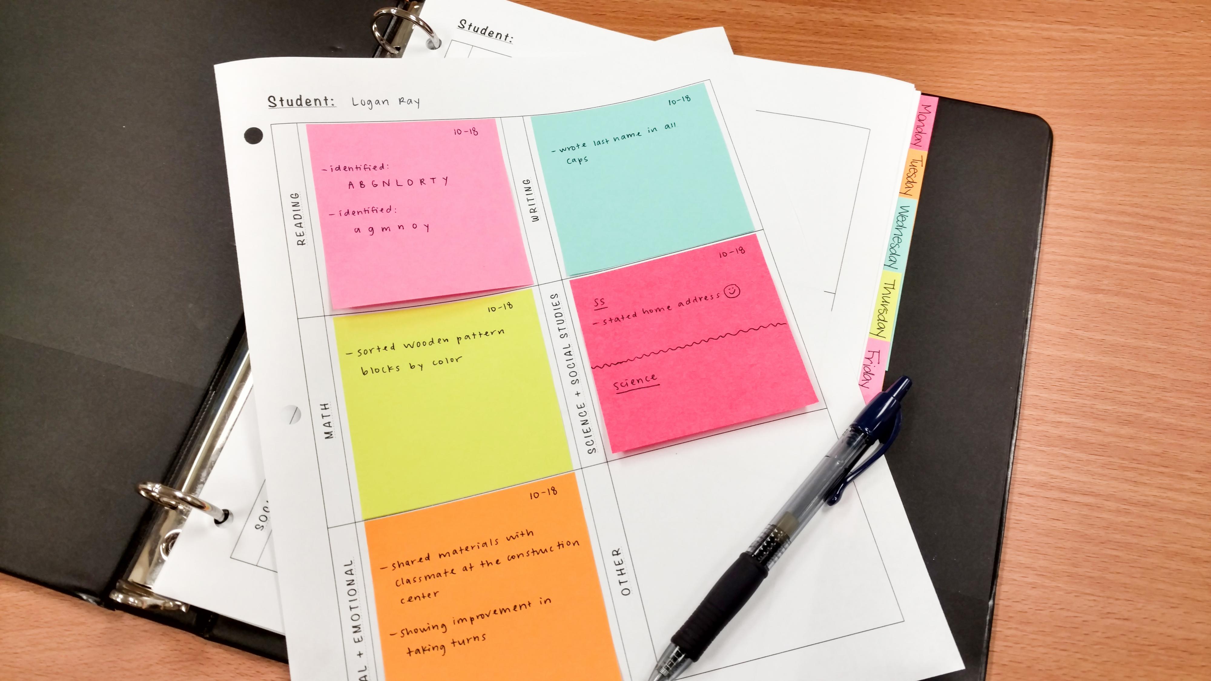A binder with worksheets featuring written notes on post-it notes