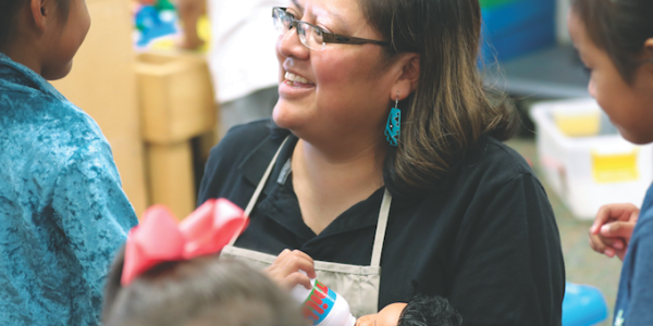 Cover of TYC's February/March 2019 Issue Teacher playing dolls with her students