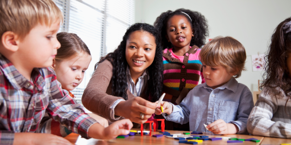 a teacher demonstrating a craft with children