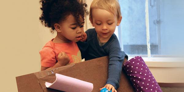 Two toddlers playing with materials