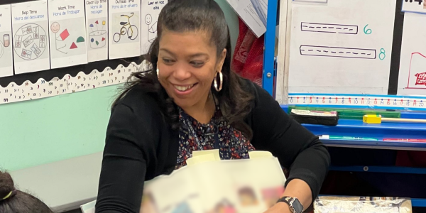 a teacher reading a book to children