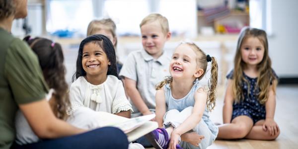 children listening to a teacher talking