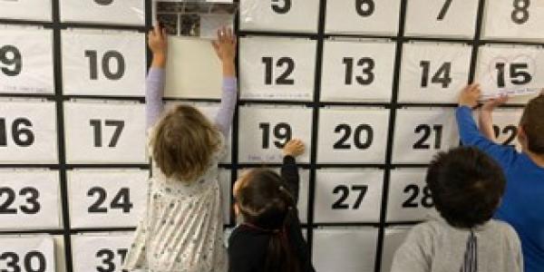 Children playing with a big calendar