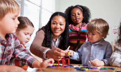 a teacher demonstrating a craft with children