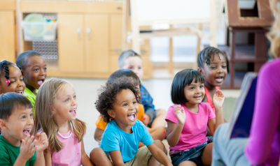 A group of children listening to their teacher.