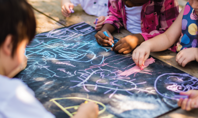 Children drawing with chalk outside.
