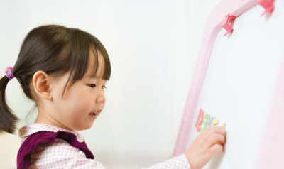 a child writing on a whiteboard