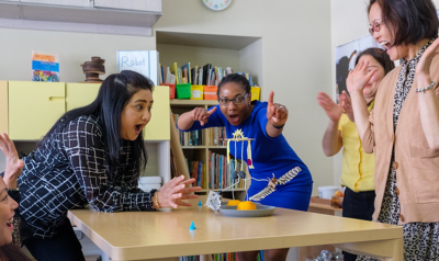 a teacher observing a craft project with children