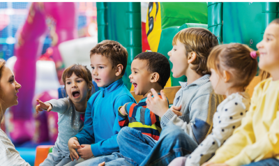 Six children laughing and talking to teacher