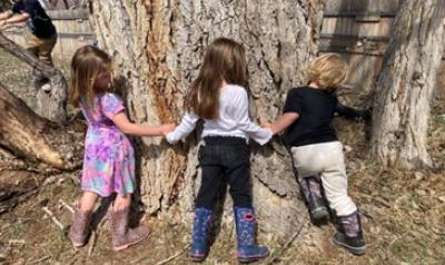 Children gathered around a tree.