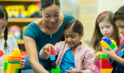 a teacher observing children playing blocks