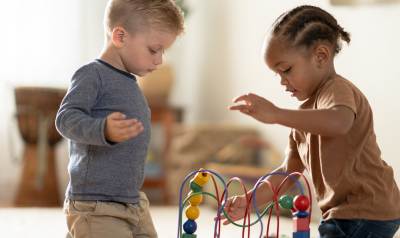 two children playing with an interactive bead toy together