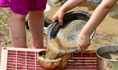 children sifting through dirt outside