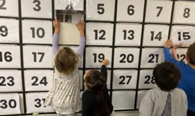 children playing with a big calendar