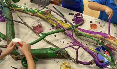 children painting tree branches in a classroom