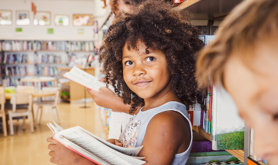 a child smiling while reading a book