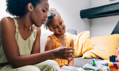 a parent exploring different toys and materials with their child