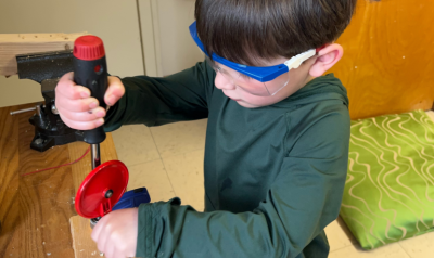 a young child with safety goggles using some tools