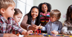 a teacher demonstrating a craft with children