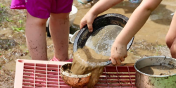 children sifting through dirt outside