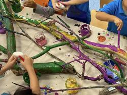 children painting tree branches in a classroom